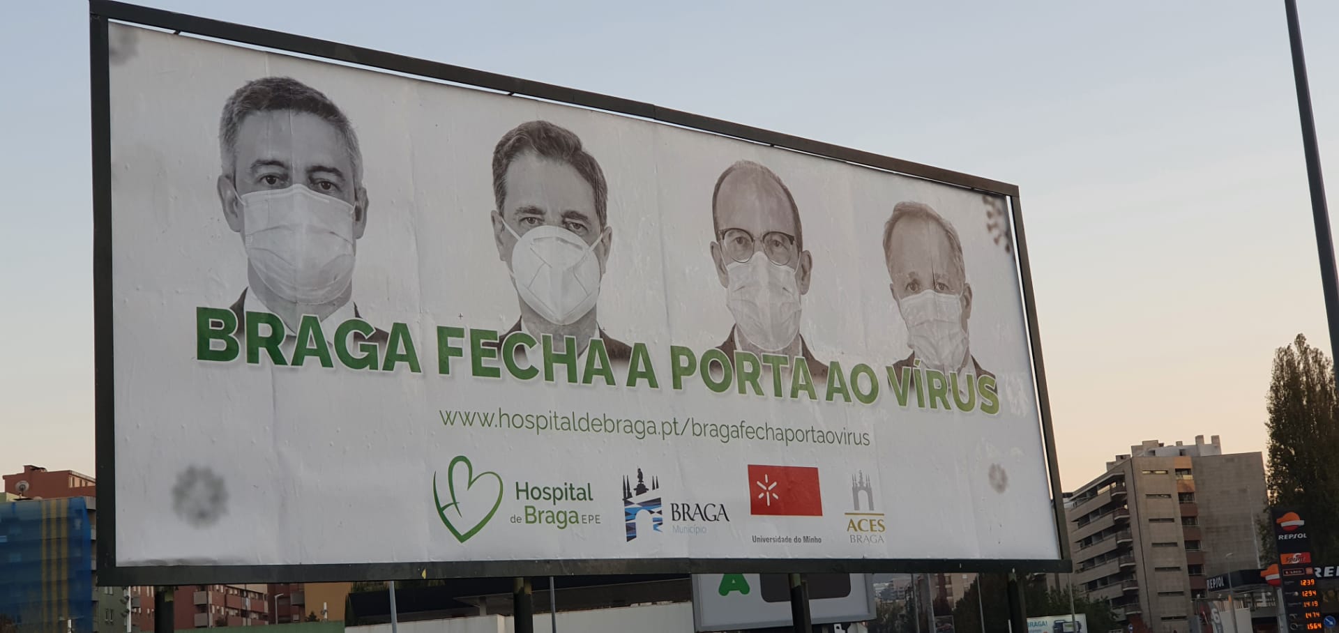 Outdoor em Braga, Portugal, com quatro homens com máscaras e a frase "Braga fecha a porta ao vírus."