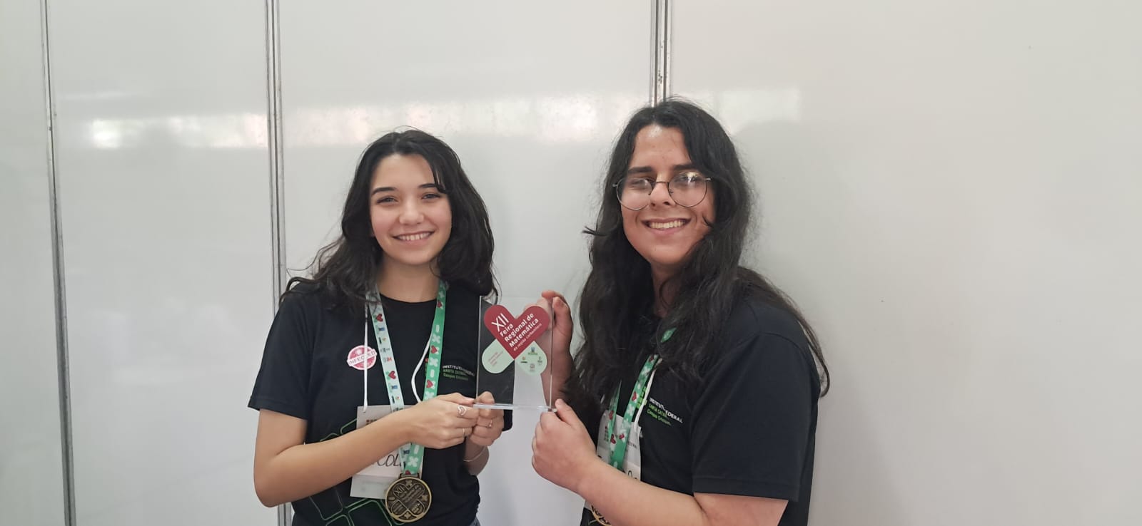 Nicolli Bordignon Brasil e Evandro Feliciano Madeira, segurando o troféu de participação da feira.