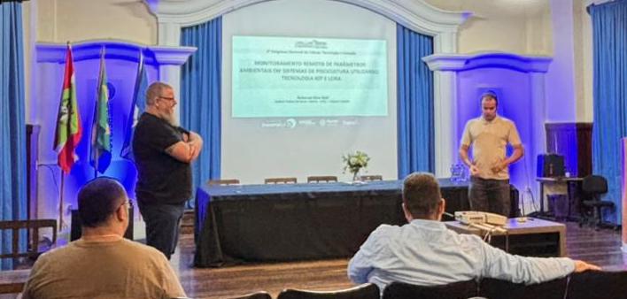 Estudante Éderr Stupp Nunes e professor Carlos Filipe Gonçalves dos Santos na apresentação do trabalho.