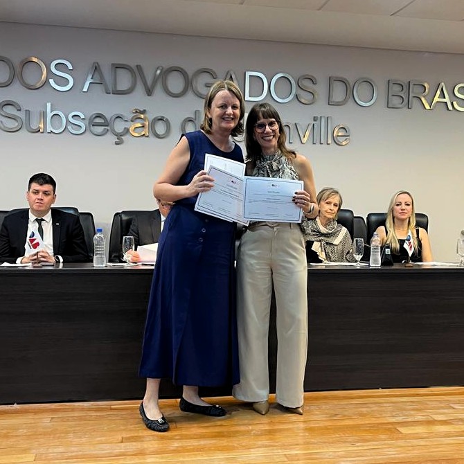 Entrega do certificado de publicação do Vinicios para professora Andrea