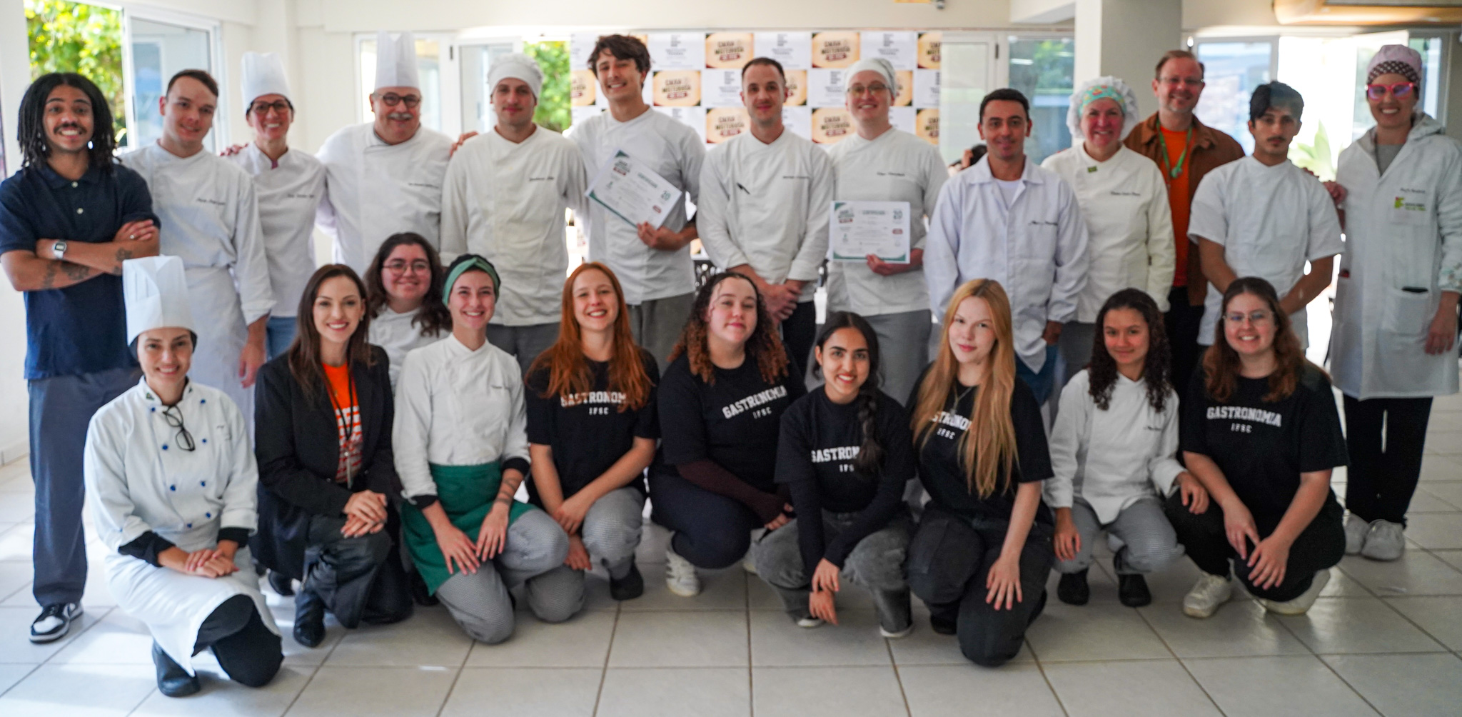 As professoras Bruna Dorabiallo e Nicole Pelaez, junto com os estudantes que organizaram o evento, e os jurados Caio Monti, Janaína Peixer e Vini de Luca