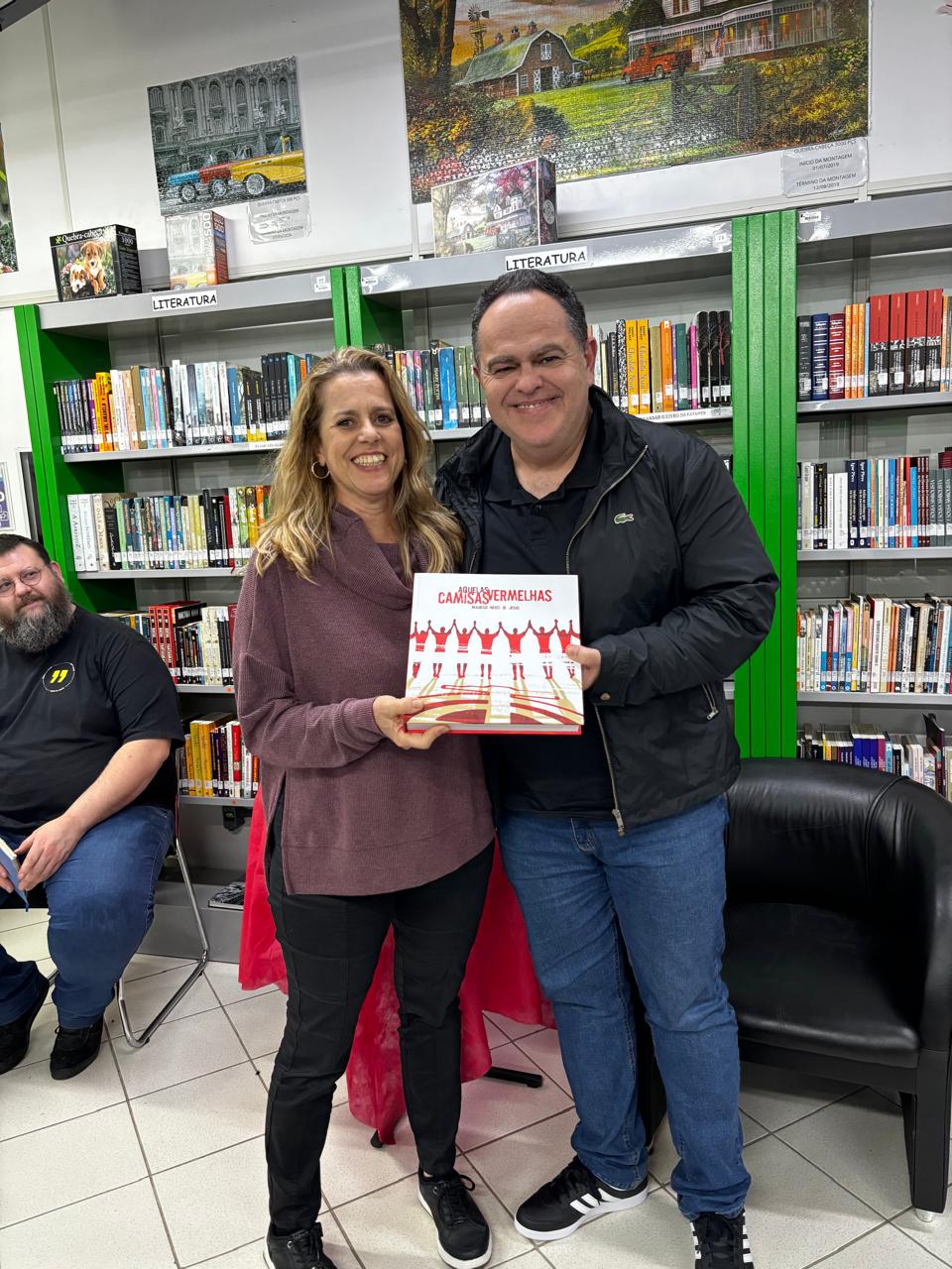A bibliotecária Luciana Schmidt recebe as obras doadas pelo escritor Mauricio Neves de Jesus ao acervo da biblioteca do IFSC Câmpus Lages.